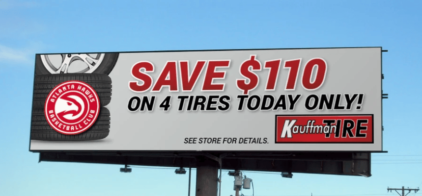 Billboard advertising $110 off four tires, with stacked tires and an Atlanta Hawks logo.